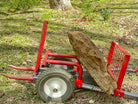 Red tree removal tool with a large rock on a grassy area